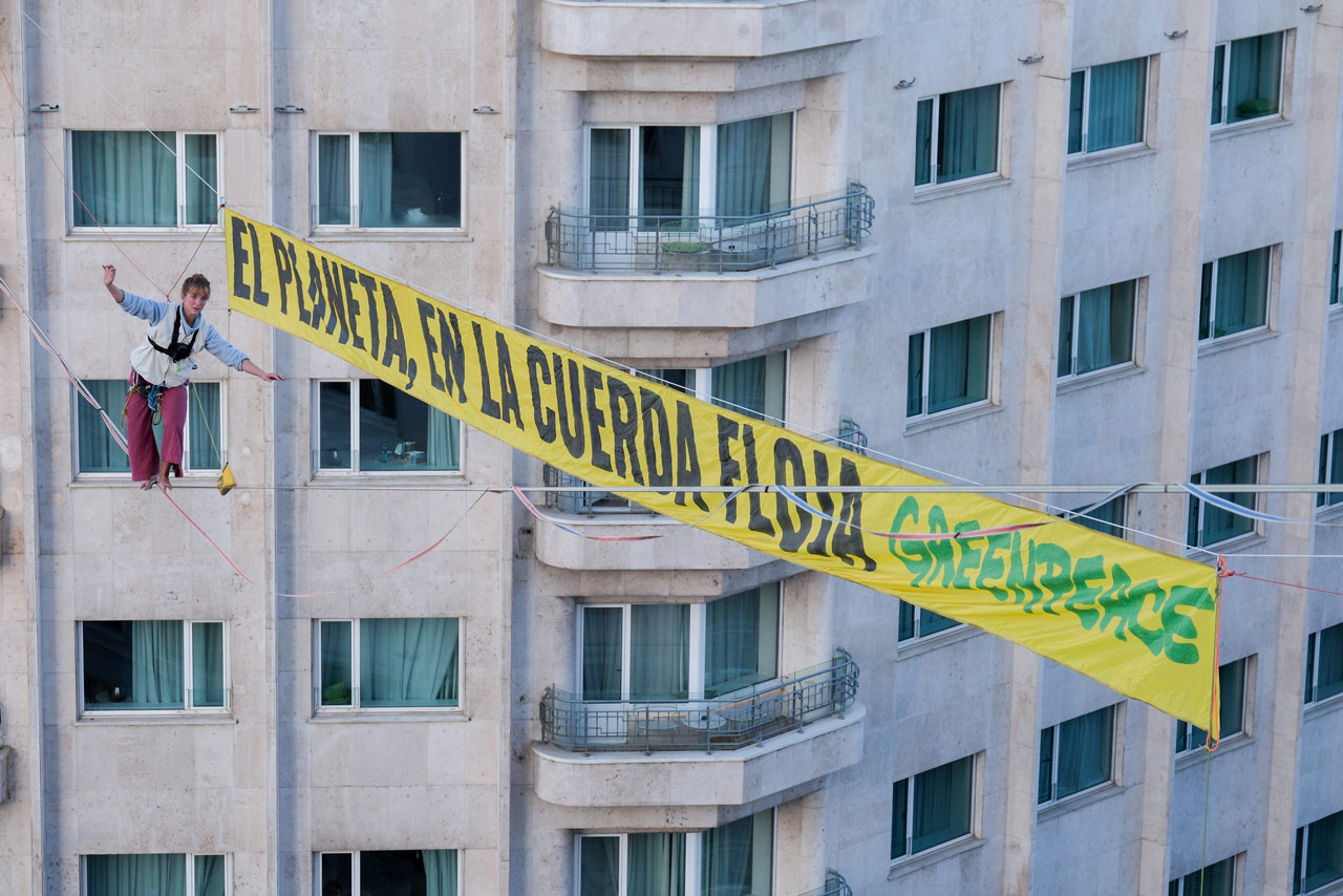 Una activista de Greenpeace denuncia la inacción climática caminando sobre el cielo de Madrid por el inicio de la COP30